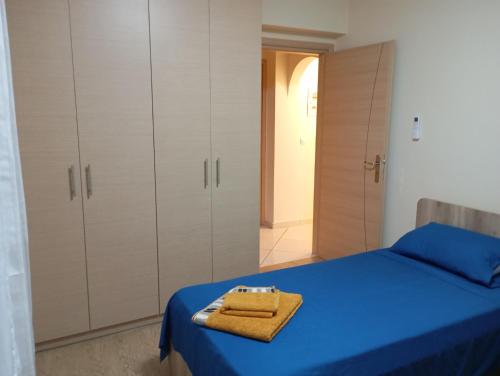 a bedroom with a blue bed and white cabinets at Casa Azul Nea Makri in Nea Makri