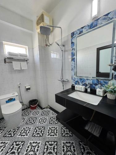 a bathroom with a sink and a mirror and a toilet at Sunflower Hotel by Huong Duong Hotel - Thanh Hoa in Thanh Hóa