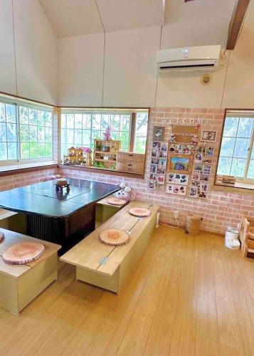 a large kitchen with a table and a brick wall at With BBQ terrace & dog run A private house full of fun, right by the sea and surf spots in Kashima