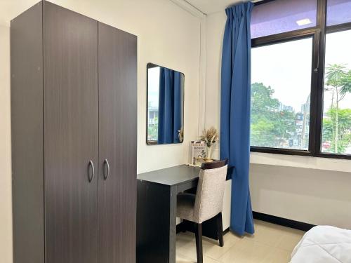 a bedroom with a desk and a cabinet and a window at Homigo - PWTC in Kuala Lumpur