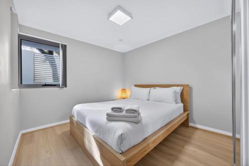 ein Schlafzimmer mit einem Bett mit weißen Laken und einem Fenster in der Unterkunft Rockingham Corporate Retreat in Rockingham