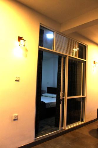 a room with a glass door with a bed in it at Ella Rock Land in Ella