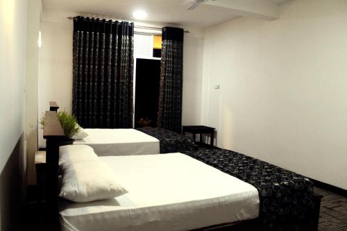 a hotel room with two beds and a window at Ella Rock Land in Ella