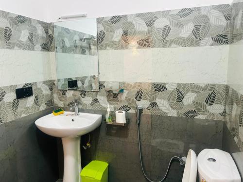 un bagno con lavandino, doccia e specchio di Olive Cottage ad Ahangama