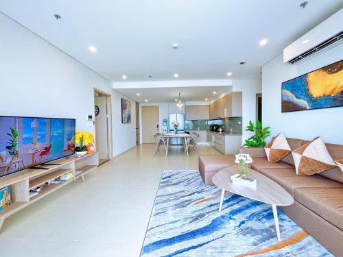 a living room with a couch and a large tv at The Song Apartment 5 Stars Vung Tau - Căn Hộ Du Lịch 5 Sao Cạnh Biển - Dumin's Homestay in Vung Tau