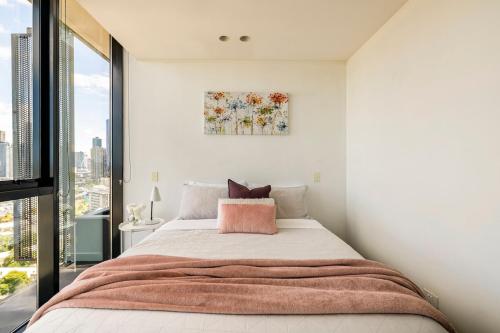 a bedroom with a large bed and a large window at Sleek&Stylish Corner Apt on TopFloor Southbank Vic in Melbourne