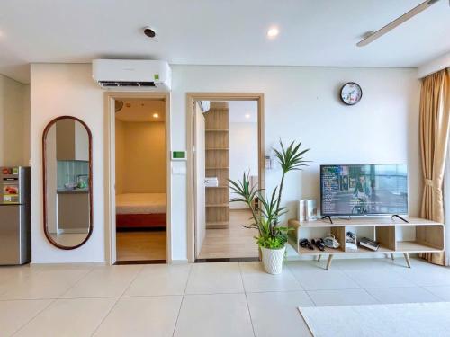 a living room with a tv and a mirror at The Song Apartment 5 Stars Vung Tau - Căn Hộ Du Lịch 5 Sao Cạnh Biển - Dumin's Homestay in Vung Tau