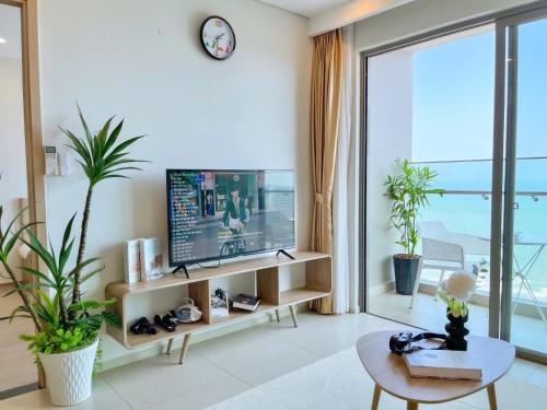 a living room with a tv and a large window at The Song Apartment 5 Stars Vung Tau - Căn Hộ Du Lịch 5 Sao Cạnh Biển - Dumin's Homestay in Vung Tau