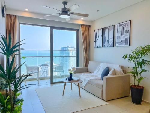 a living room with a couch and a large window at The Song Apartment 5 Stars Vung Tau - Căn Hộ Du Lịch 5 Sao Cạnh Biển - Dumin's Homestay in Vung Tau
