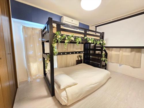 a bedroom with a black bunk bed with ivy at 歌舞伎町ヤスオroom in Tokyo