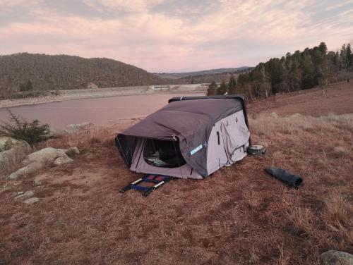 a tent sitting in a field next to a lake at Van near Jindy - Thredbo and ski areas in Jindabyne