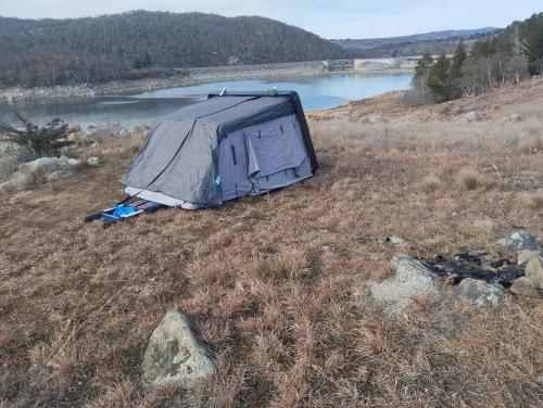 a tent sitting in a field next to a lake at Van near Jindy - Thredbo and ski areas in Jindabyne