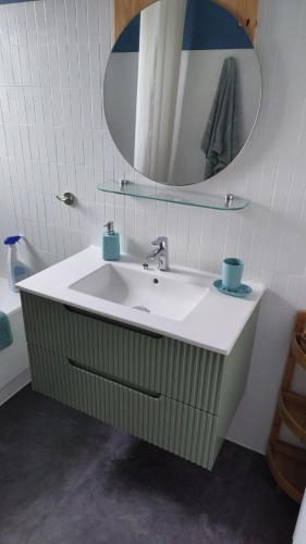 une salle de bain avec un lavabo et un miroir dans l'établissement La clé des falaises Meublé de tourisme 3 étoiles avec petite vue mer et au bord du GR 34, à Plouézec