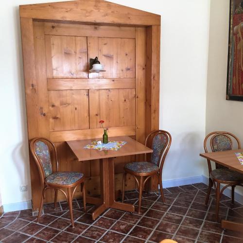 a table and chairs in a room with a wooden wall at Hotel-Pension Teutonia in Braunlage