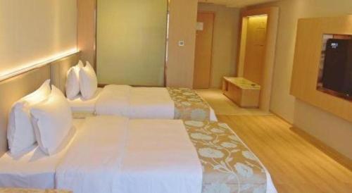 a hotel room with two beds and a flat screen tv at Chengdu Antai Century Hotel in Chengdu