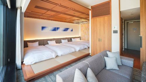 a large bed in a room with a couch at HOTEL＆SPA CENTURY MARINA HAKODATE in Hakodate