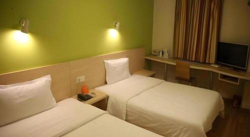 a hotel room with two beds and a television at 7 Days Inn Nanjing Gaochun Metro Station in Gaochun