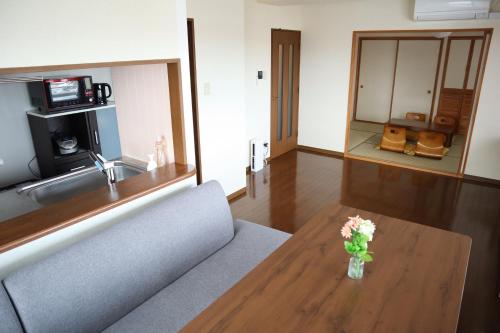 a living room with a couch and a table with flowers at STAYMoiwayama in Sapporo