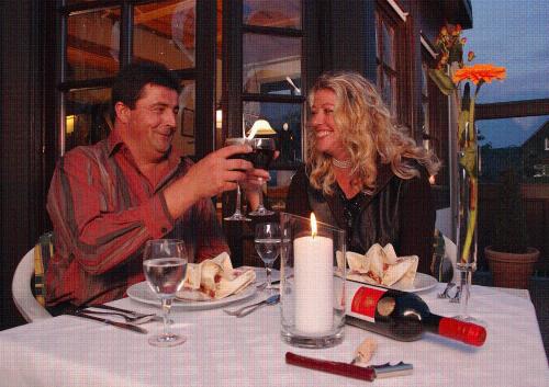 a man and woman sitting at a table drinking wine at Müllers Landhotel in Medebach