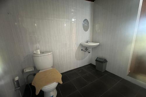 a small bathroom with a toilet and a sink at Nirwana Kintamani in Kubupenlokan