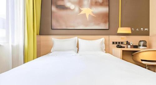 a bedroom with a large white bed and a desk at IU Hotel Kunming Jinma Bijifang Joy City in Kunming