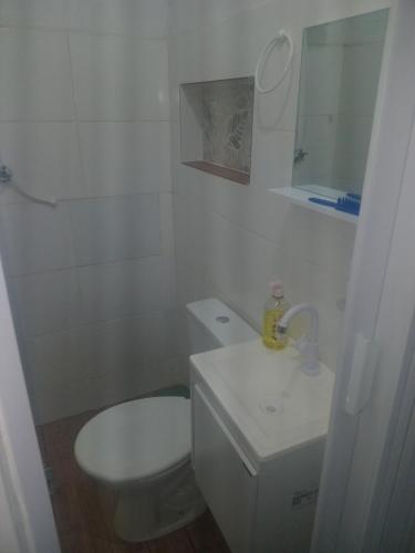 a white bathroom with a toilet and a sink at Micro-casa 2 Pedregal Novo Gama GO prox Valparaíso ideal p trabalho descanso e silêncio in Novo Gama
