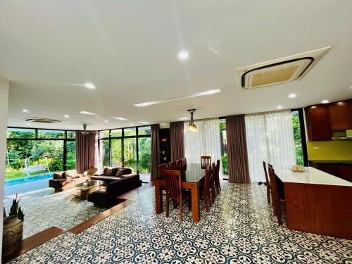 a dining room and living room with a table and chairs at Flamigo Dai Lai Resort - Villa Chủ Tự Doanh in Ngọc Quang