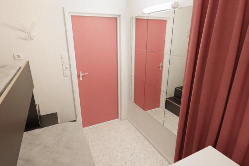 a bathroom with red sliding doors and a mirror at Citysleep in Luleå
