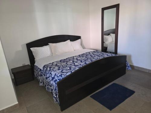 a bedroom with a large bed with a mirror at My dad's cottage in Takoradi
