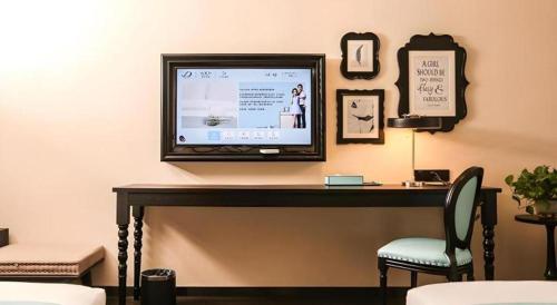 a flat screen tv sitting on top of a table at Xana Hotelle·Ji'nan Hi-tech Zone Century Avenue Tangye in Jinan