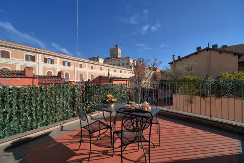 een patio met een tafel en stoelen op een balkon bij Trevi Palace Luxury Inn in Rome