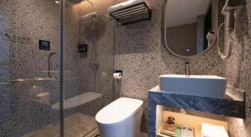 a bathroom with a toilet and a sink and a mirror at Immersing Hotel Guilin Two Rivers and Four Lakes Dongxi Alley in Guilin