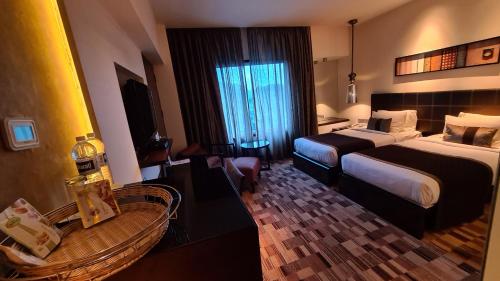 a hotel room with two beds and a table at Pride Hotel Pune in Pune