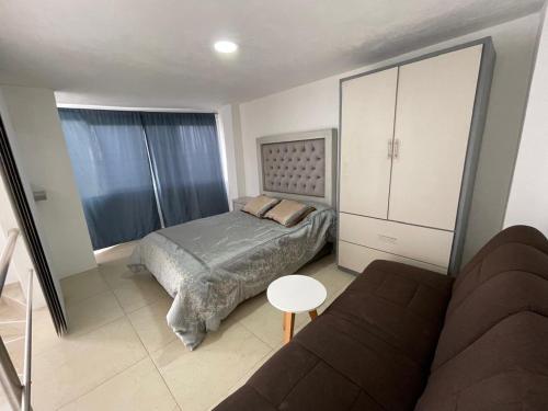 a small bedroom with a bed and a couch at Departamento Aeropuerto #1 in Toluca