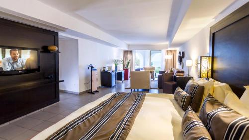 a living room with a couch and a tv at Mövenpick Hotel Gammarth Tunis in Gammarth