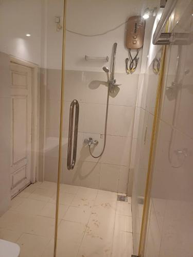 a bathroom with a shower with a glass door at JarushanInnHotel in Jaffna