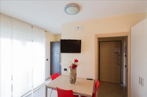 a dining room with a table and a vase with flowers at Residenza Villa Regina in Monza