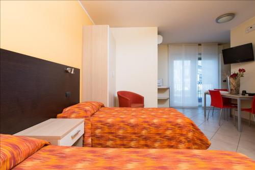 a hotel room with two beds and a table at Residenza Villa Regina in Monza