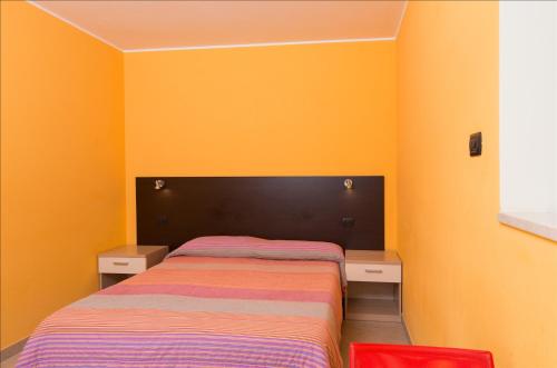a bedroom with yellow walls and a bed with two drawers at Residenza Villa Regina in Monza