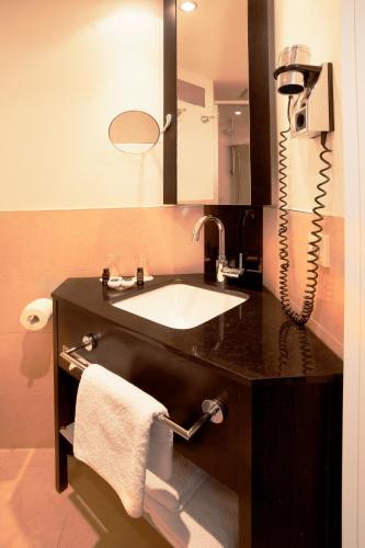 a bathroom with a sink and a phone at Hotel Victoria in Frankfurt/Main