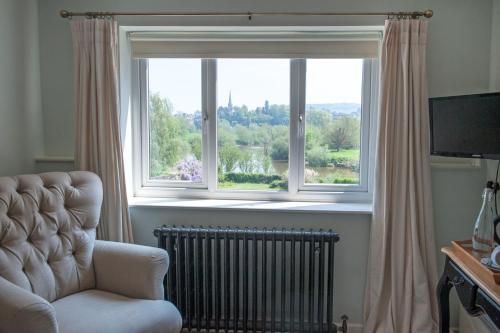 a living room with a chair and a window at The Bridge House in Ross on Wye