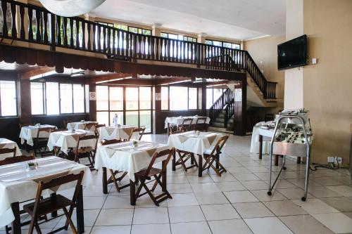 a restaurant with tables and chairs and a staircase at Hotel Plage in Rio de Janeiro