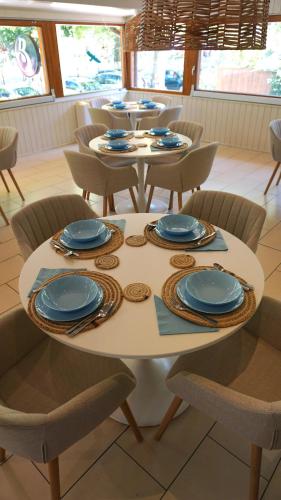 a table with chairs and blue plates on it at Balaton Colors Beach Hotel in Siófok