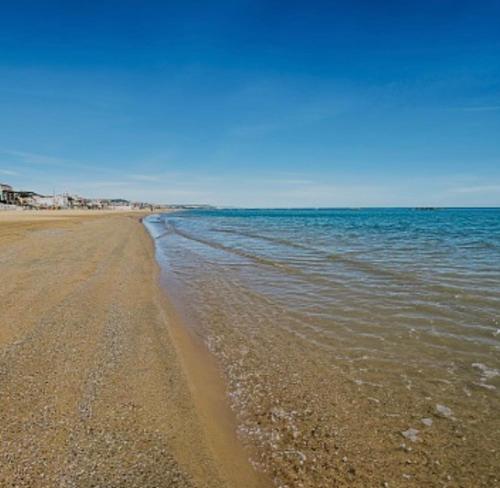 una spiaggia con acqua e cielo azzurro di Casa di Theo a Pescara