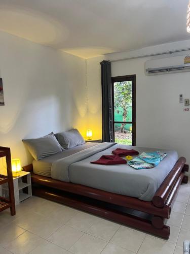 a bedroom with a large bed with a window at Tropical Paradise Leelawadee Resort in Ko Chang