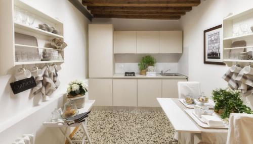 a kitchen with white cabinets and a table and chairs at Laguna724 in Venice
