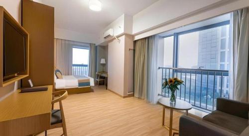 a hotel room with a balcony with a bed and a room at VX Hotel Wuxi Xinwu District Executive Center Wanda Plaza in Wuxi