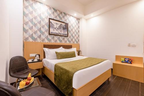a hotel room with a bed and a chair at Yahobhoomi Hotel Tashree Dwarka Sector 23 in New Delhi