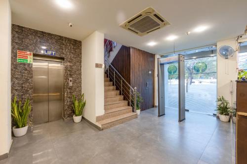 an office lobby with a door and stairs with plants at Yahobhoomi Hotel Tashree Dwarka Sector 23 in New Delhi