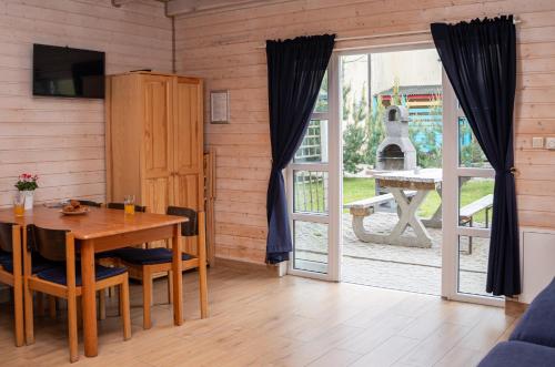 a dining room with a table and a sliding glass door at Domki Primore in Władysławowo